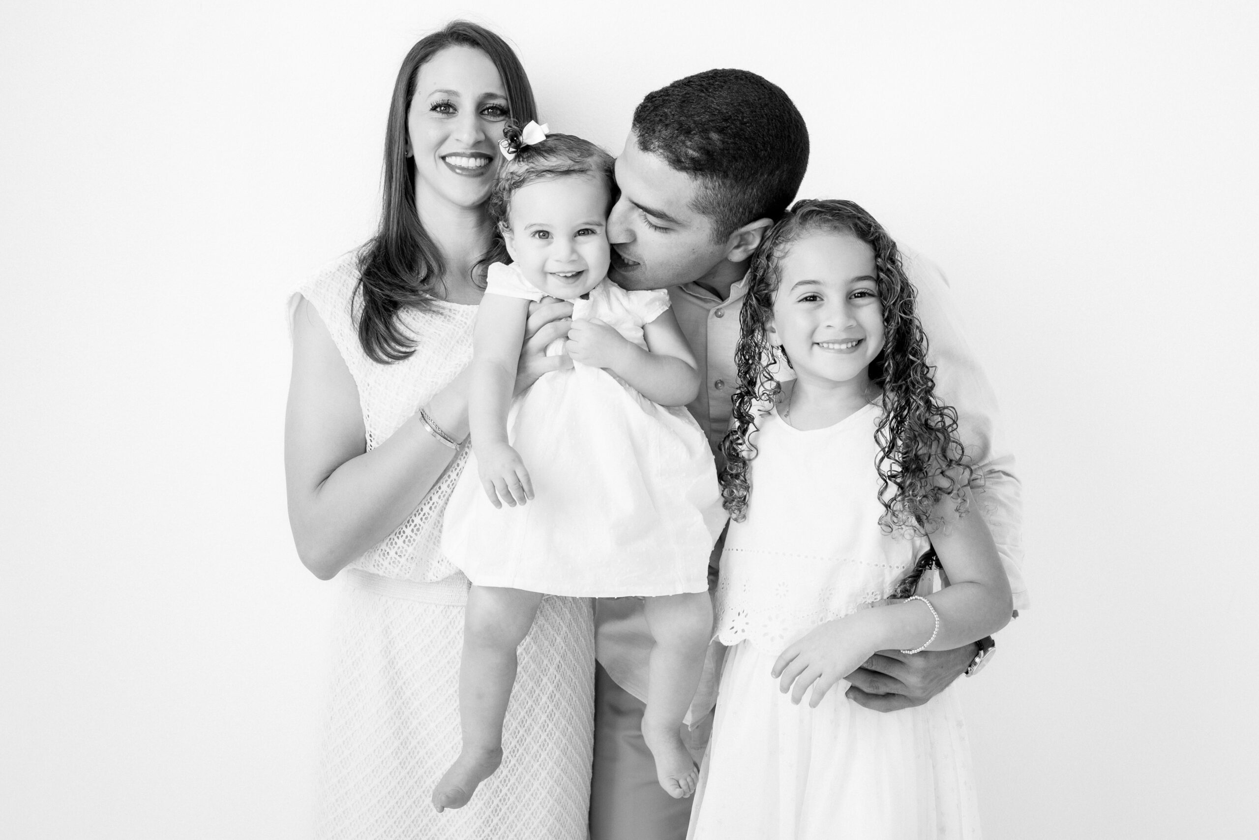 Black and White studio portrait of a family with two daughters in Houston.